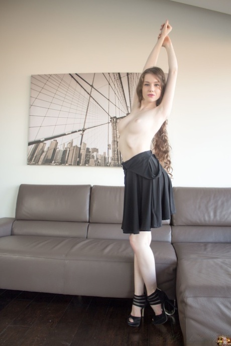 Arousing young model sheds black dress to pose hot body naked in high heels